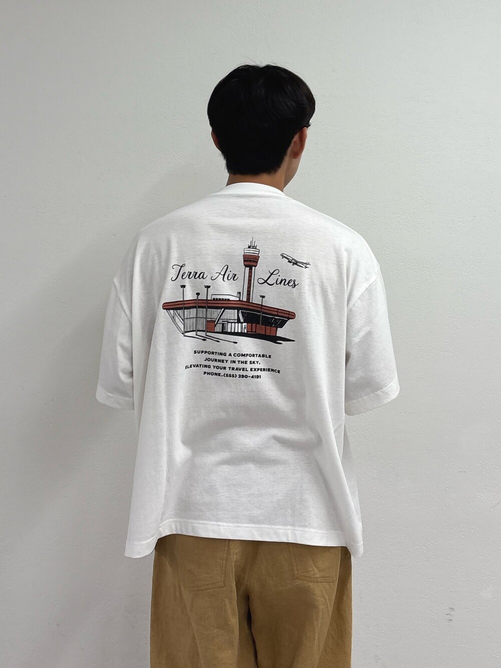 ホワイト系のTシャツ/カットソー、ベージュ系のチノパンツを着用したメンズの夏コーディネートの3枚目の写真