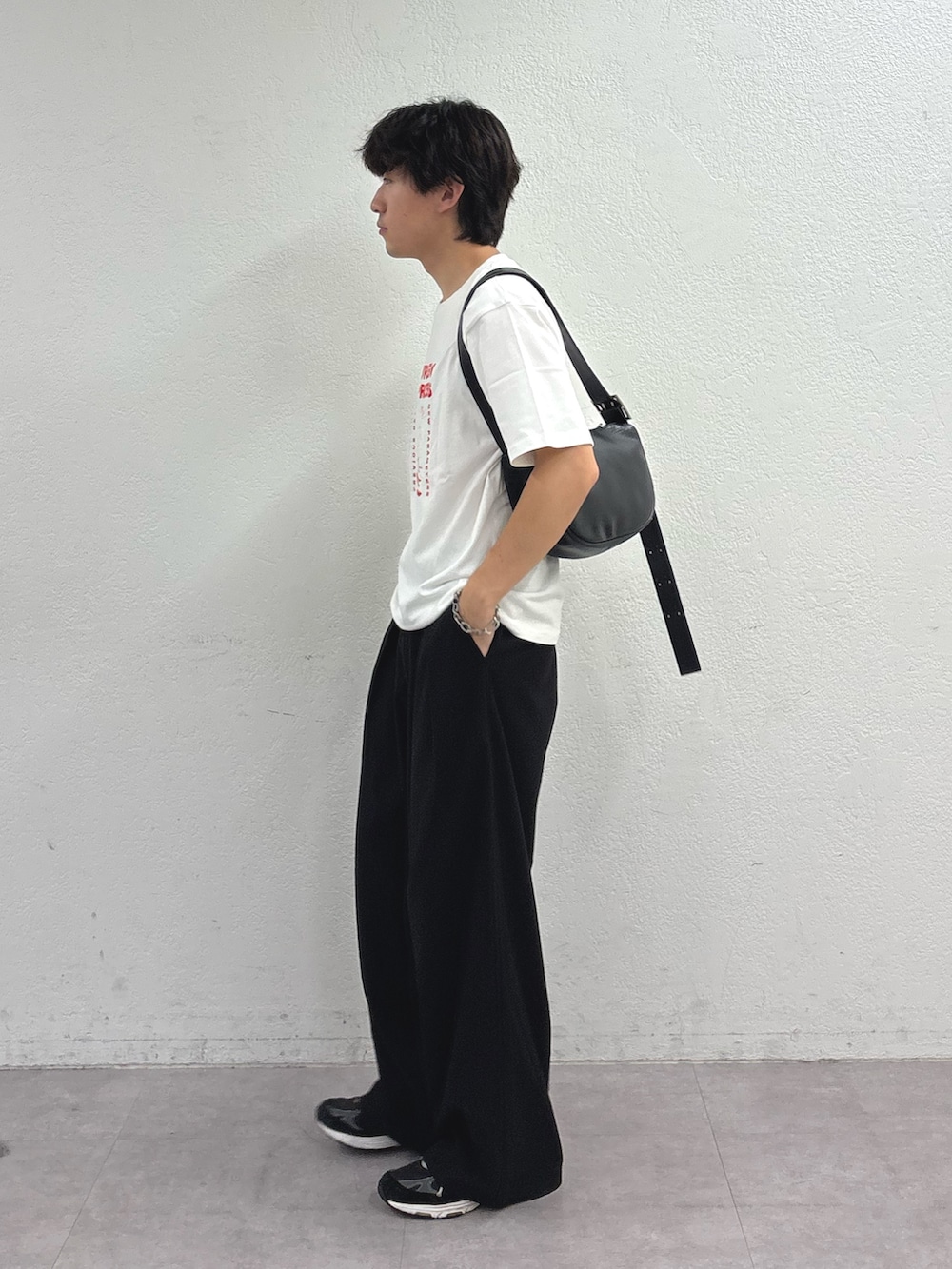 ホワイト系のTシャツ/カットソー、ブラック系のショルダーバッグ、ブラック系のスラックスを着用したメンズの夏コーディネートの2枚目の写真