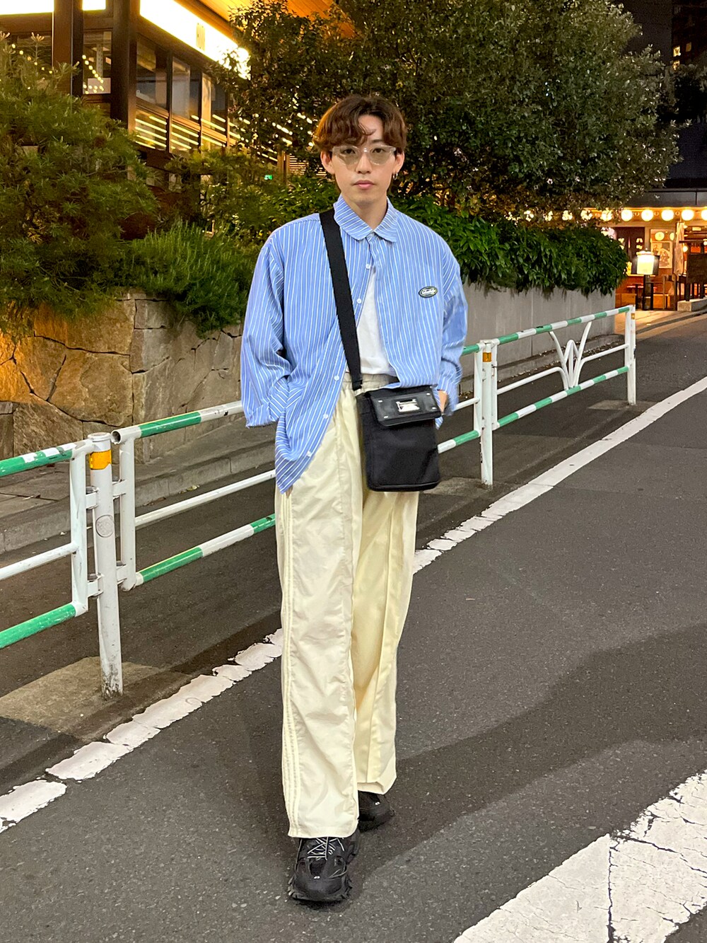 ブラック系のスニーカー、ホワイト系のスウェットパンツ、ブラック系のバッグを着用したメンズの夏コーディネートの3枚目の写真