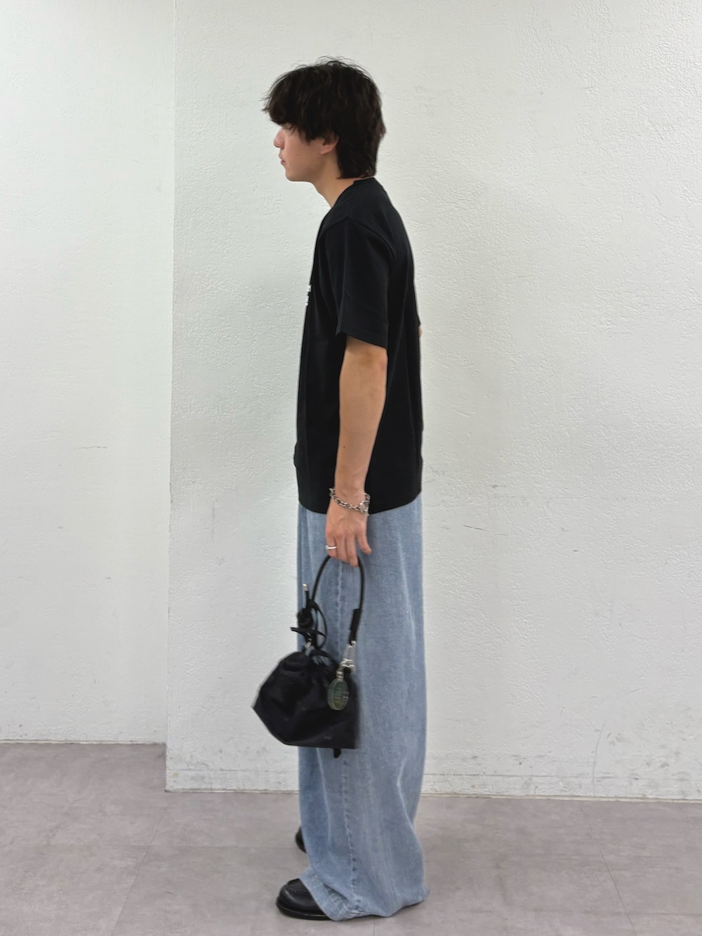 ブラック系のTシャツ/カットソー、ブルー系のデニムパンツ、ブラック系のショルダーバッグを着用したメンズの夏コーディネートの2枚目の写真