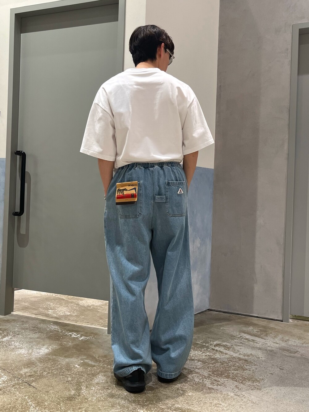 ブラック系のスニーカー、ブルー系のデニムパンツ、ホワイト系のTシャツ/カットソーを着用したメンズの春コーディネートの3枚目の写真