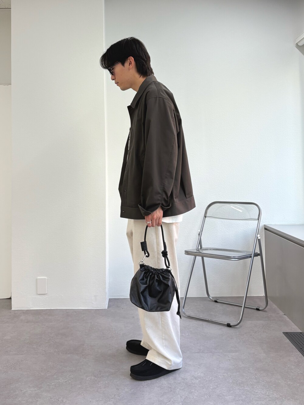 グレー系のブルゾン、ホワイト系のTシャツ/カットソー、ホワイト系のチノパンツを着用したメンズの春コーディネートの2枚目の写真