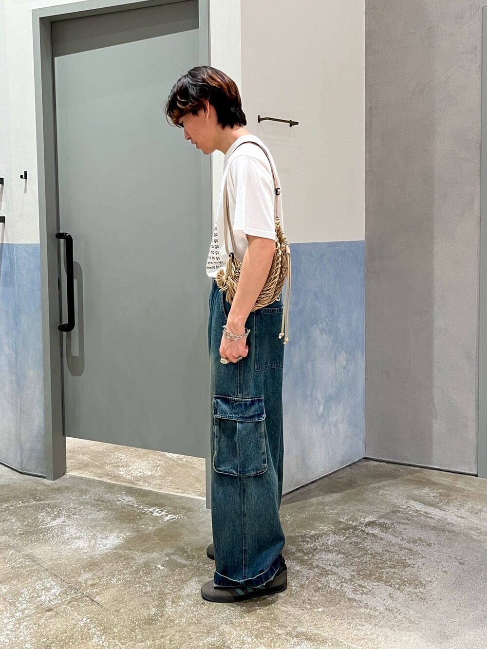 ブルー系のカーゴパンツ、グレー系のスニーカー、ホワイト系のTシャツ/カットソーを着用したメンズの夏コーディネートの2枚目の写真