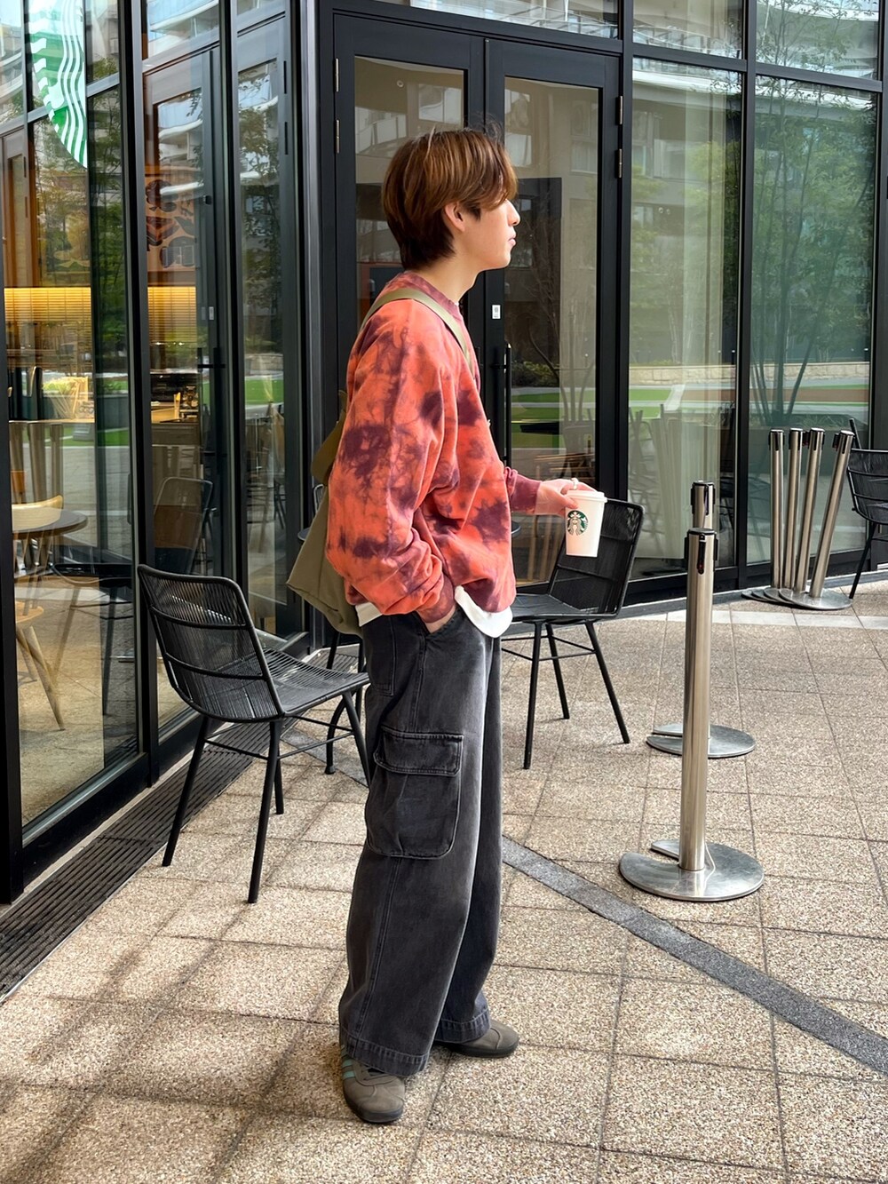 グレー系のスニーカー、ブラック系のカーゴパンツ、レッド系のスウェットを着用したメンズの冬コーディネートの2枚目の写真