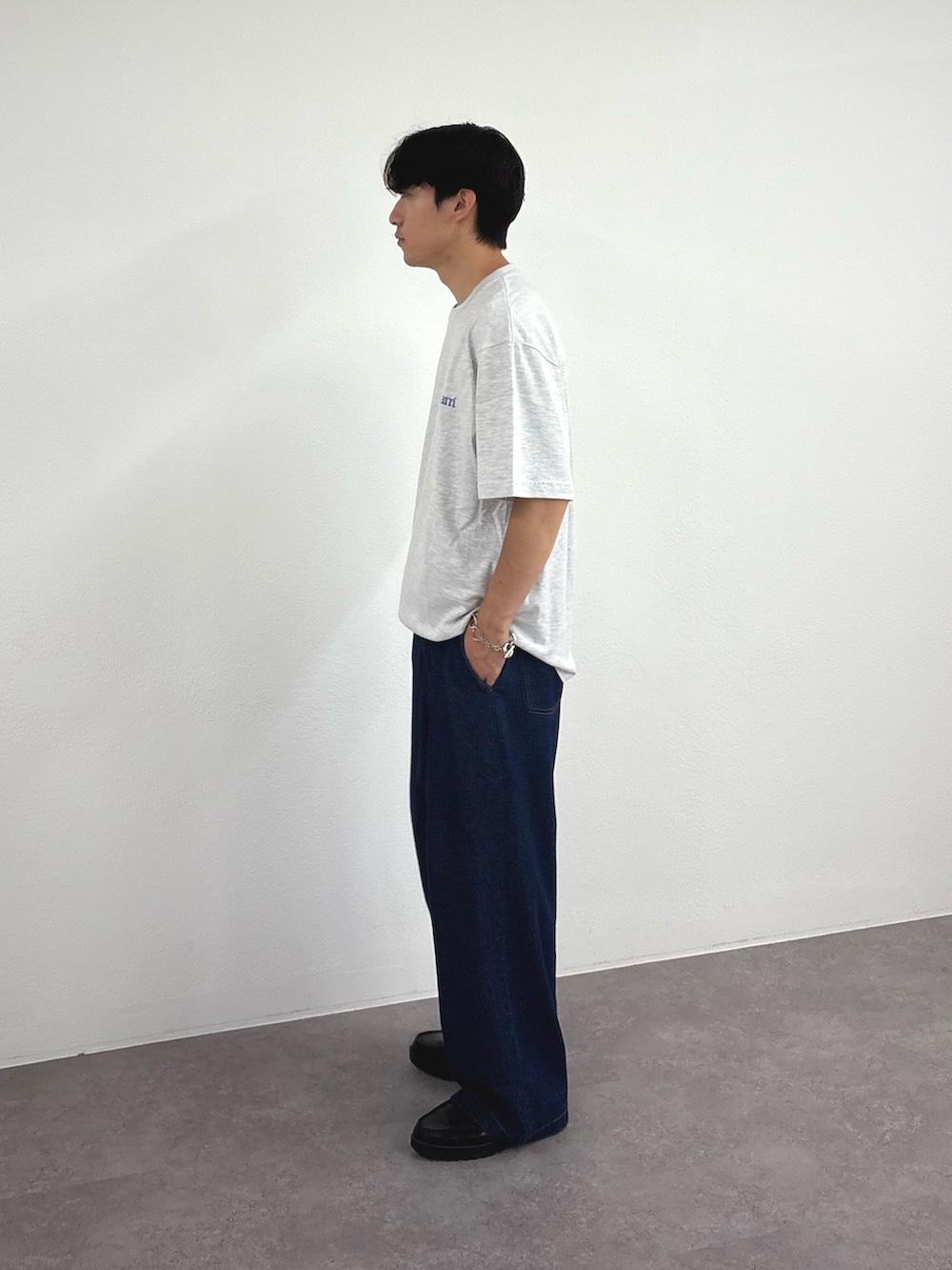 グレー系のTシャツ/カットソー、ブルー系のデニムパンツを着用したメンズの夏コーディネートの2枚目の写真