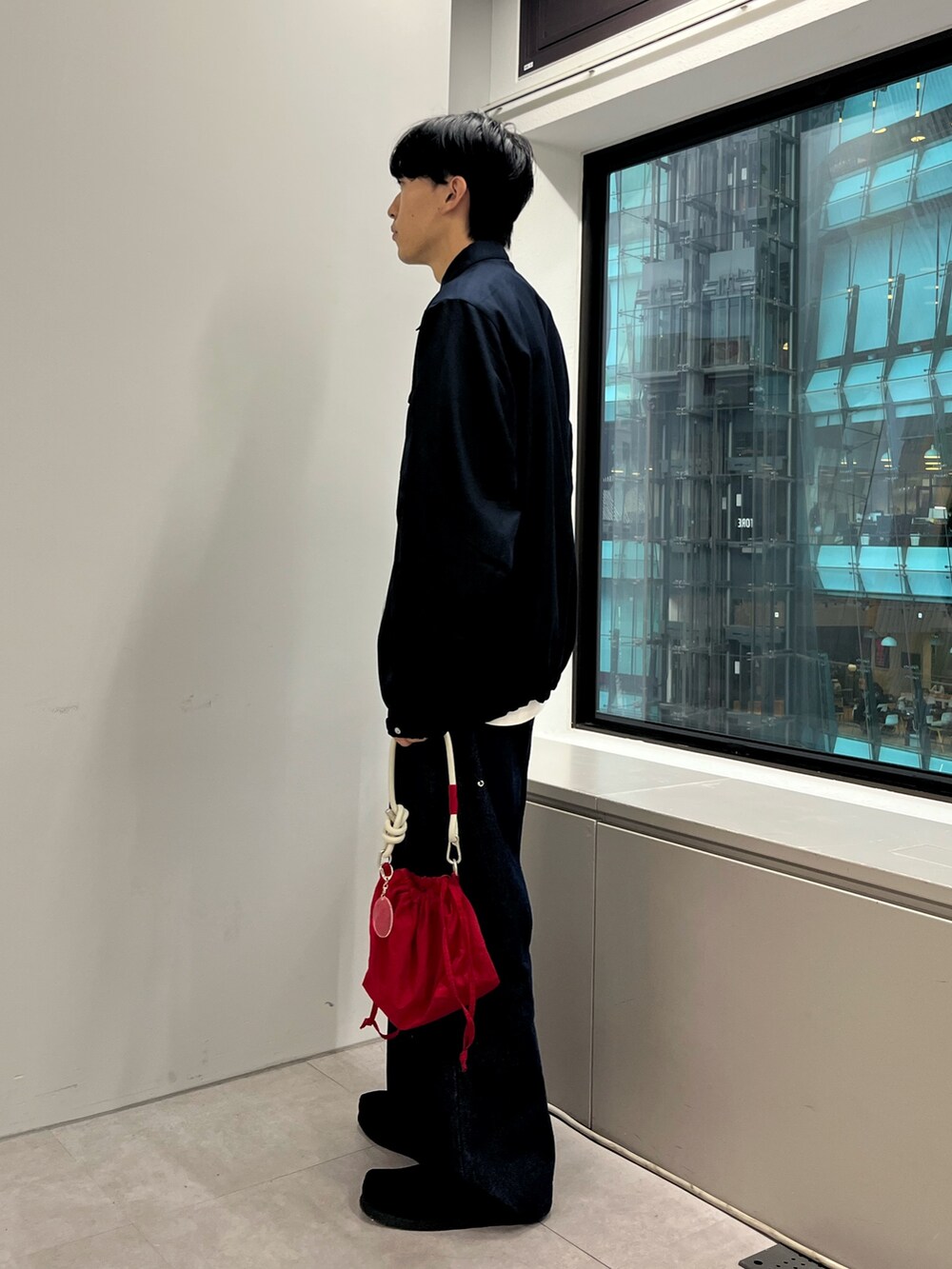 ブラック系のスニーカー、ブルー系のブルゾン、レッド系のショルダーバッグを着用したメンズの秋コーディネートの2枚目の写真