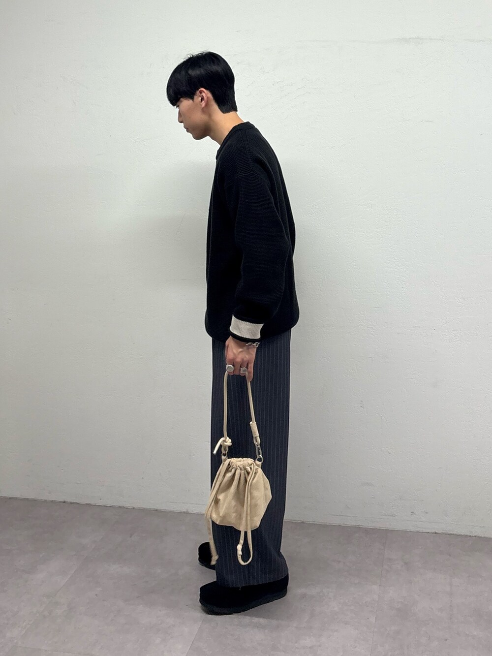 ブラック系のニット/セーター、グレー系のスラックス、ブラック系のスニーカーを着用したメンズの冬コーディネートの2枚目の写真