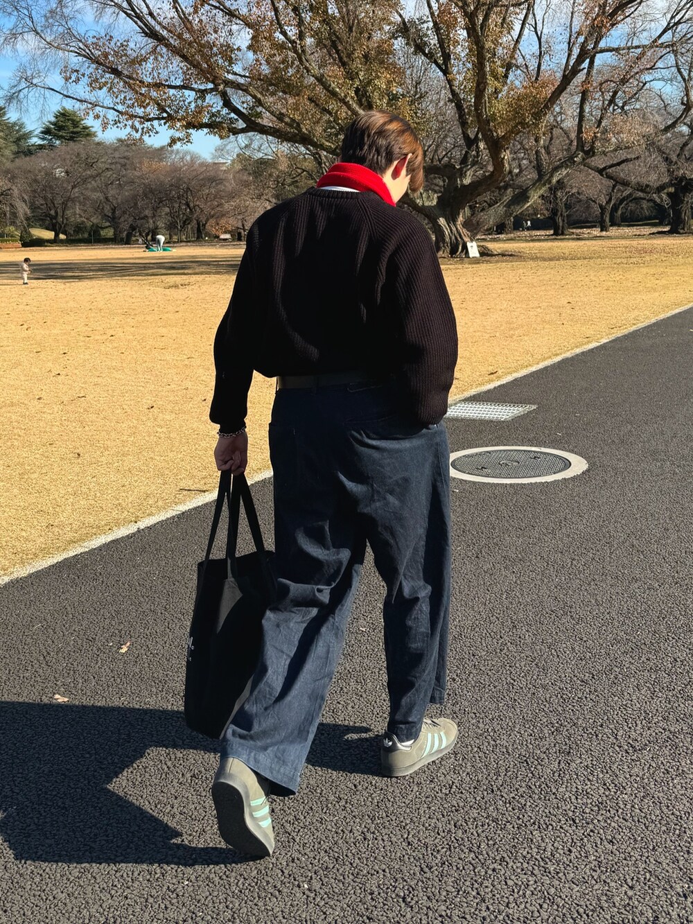 グレー系のスニーカー、ブラック系のトートバッグ、ブルー系のデニムパンツを着用したメンズの冬コーディネートの2枚目の写真