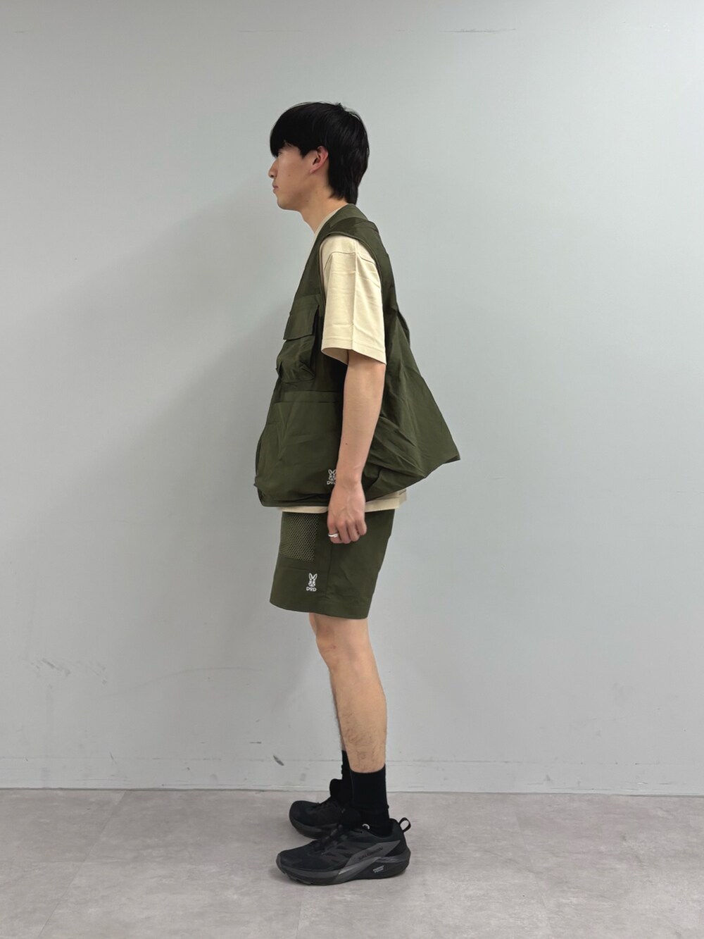 グリーン系のベスト、ベージュ系のTシャツ/カットソー、グリーン系のその他パンツを着用したメンズの春コーディネートの2枚目の写真