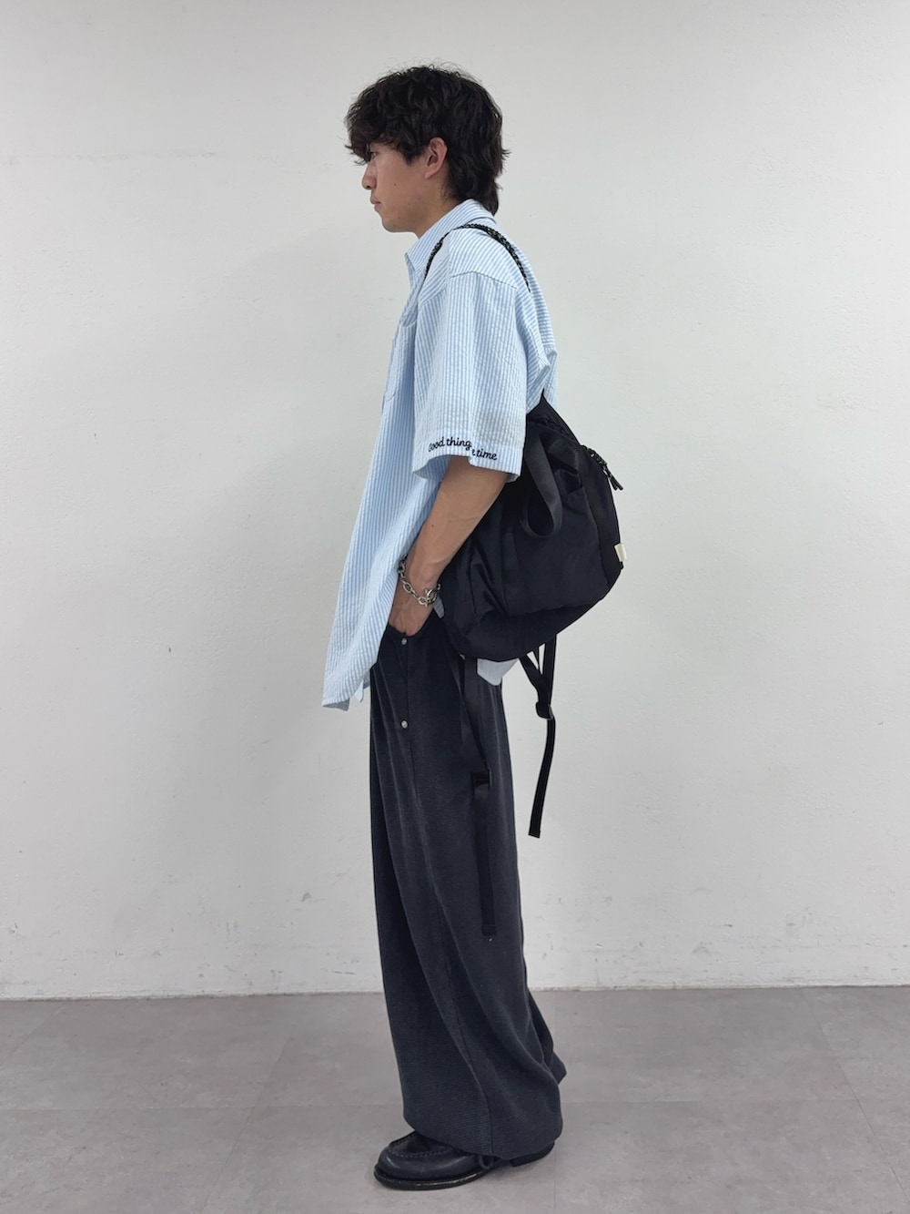 ブルー系のシャツ/ブラウス、ブラック系のトートバッグ、ホワイト系のTシャツ/カットソーを着用したメンズの春コーディネートの2枚目の写真