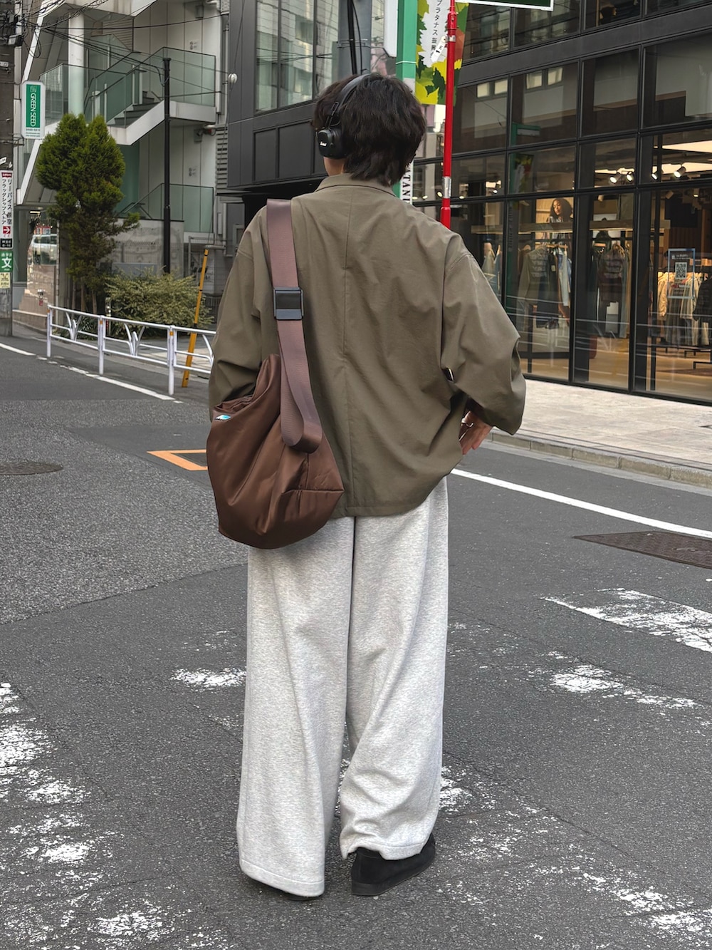 グリーン系のテーラードジャケット、ブラウン系のショルダーバッグ、グレー系のその他パンツを着用したメンズの冬コーディネートの2枚目の写真