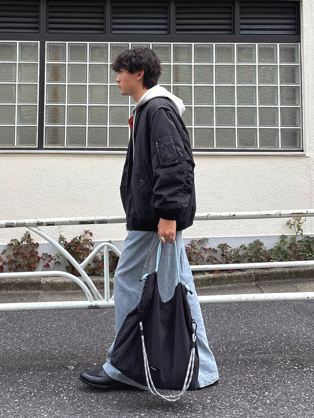 ブラック系のMA-1、グレー系のパーカー、ブルー系のデニムパンツを着用したメンズの秋コーディネートの2枚目の写真