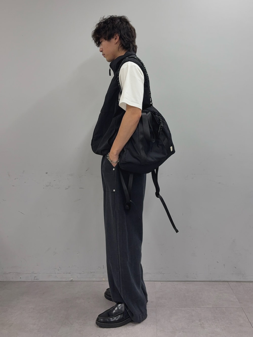 ブラック系のベスト、ホワイト系のTシャツ/カットソー、ブラック系のトートバッグを着用したメンズの夏コーディネートの2枚目の写真
