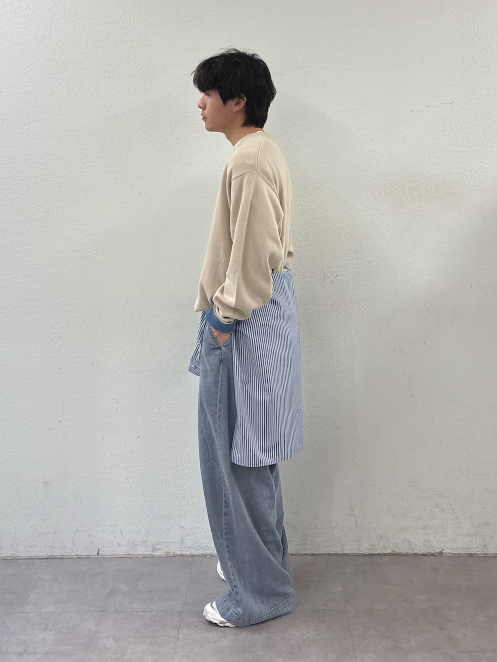 ホワイト系のニット/セーター、ブルー系のシャツ/ブラウス、ブルー系のデニムパンツを着用したメンズの春コーディネートの2枚目の写真