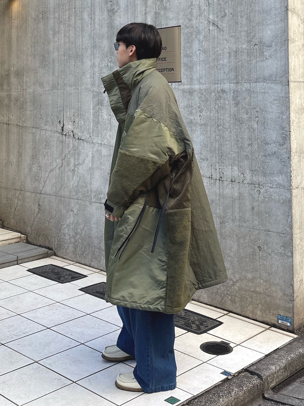 グリーン系のモッズコート、ブルー系のデニムパンツを着用したメンズの冬コーディネートの2枚目の写真