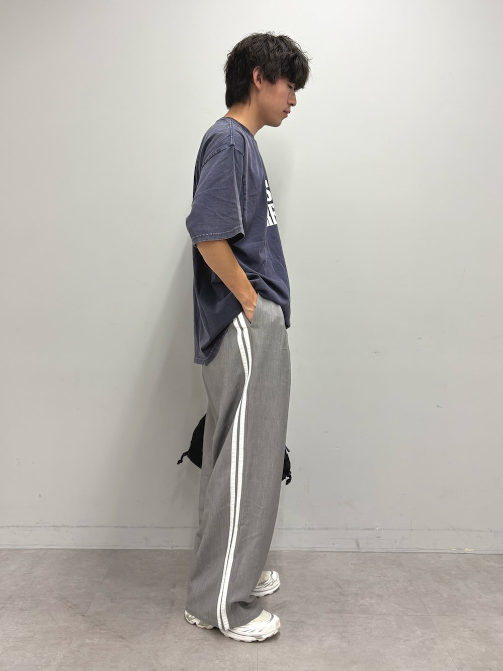 ブルー系のTシャツ/カットソー、グレー系のスラックス、ブラック系のトートバッグを着用したメンズの夏コーディネートの2枚目の写真