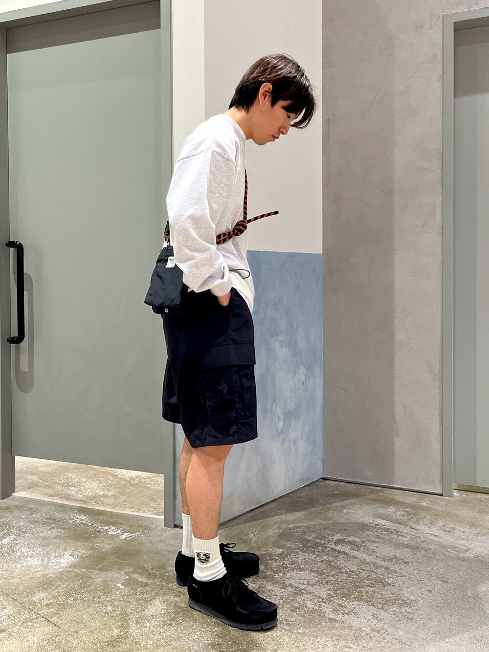 ブラック系のショルダーバッグ、グレー系のTシャツ/カットソー、ブラック系のカーゴパンツを着用したメンズの春コーディネートの2枚目の写真