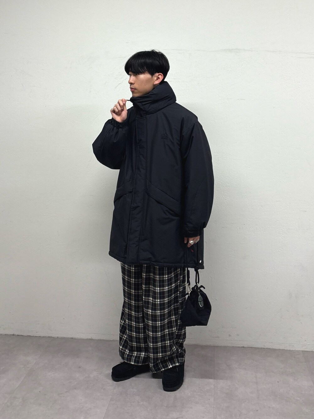 ブラック系のダウンジャケット/コート、レッド系のニット/セーター、ブラック系のその他パンツを着用したメンズの冬コーディネートの2枚目の写真