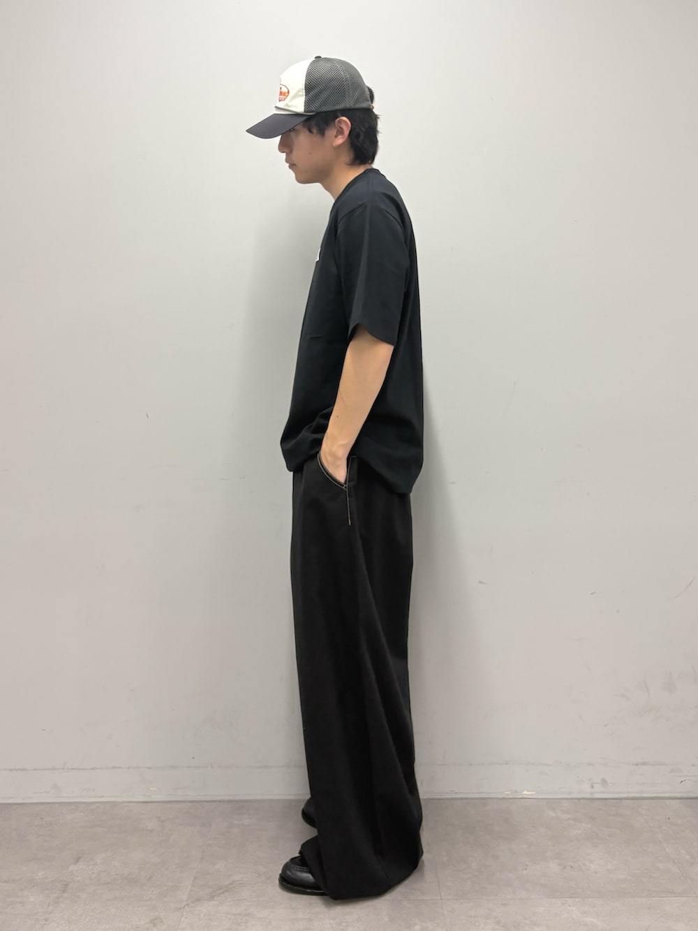 ブラック系のTシャツ/カットソー、ブラック系のチノパンツ、グレー系のキャップを着用したメンズの春コーディネートの2枚目の写真