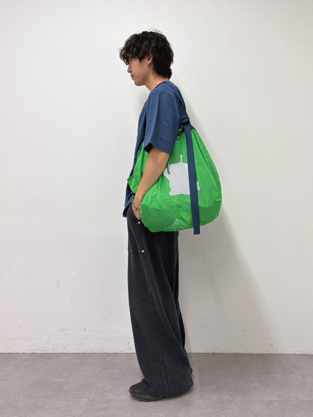 ブルー系のTシャツ/カットソー、グリーン系のトートバッグ、ブラック系のスウェットパンツを着用したメンズの夏コーディネートの2枚目の写真