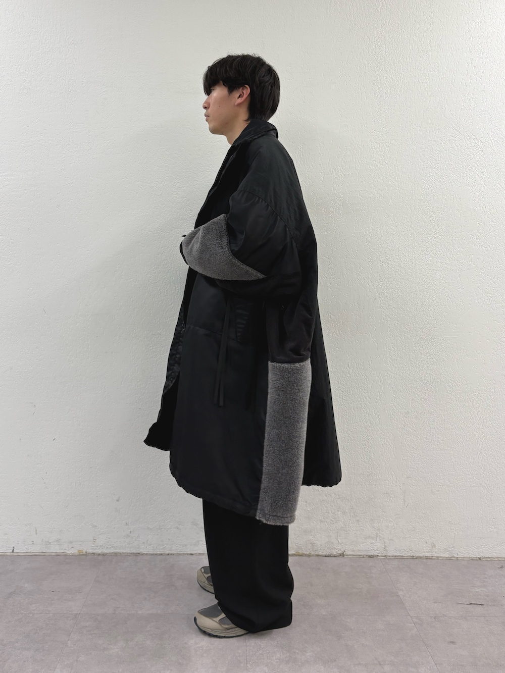 ブラック系のモッズコート、ホワイト系のスウェット、ブラック系のその他パンツを着用したメンズの冬コーディネートの2枚目の写真