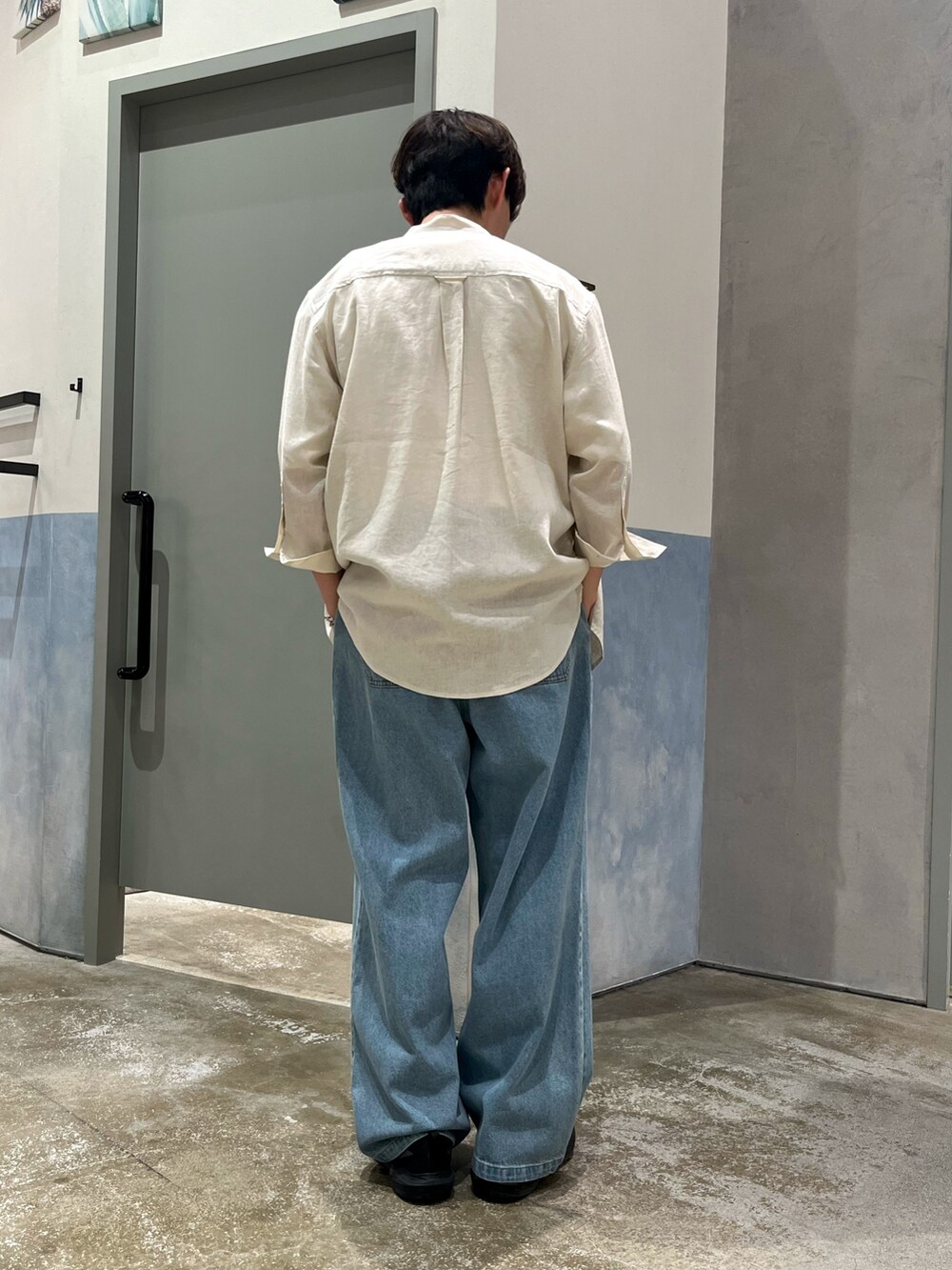 ブラック系のスニーカー、ブルー系のデニムパンツ、ベージュ系のシャツ/ブラウスを着用したメンズの春コーディネートの3枚目の写真