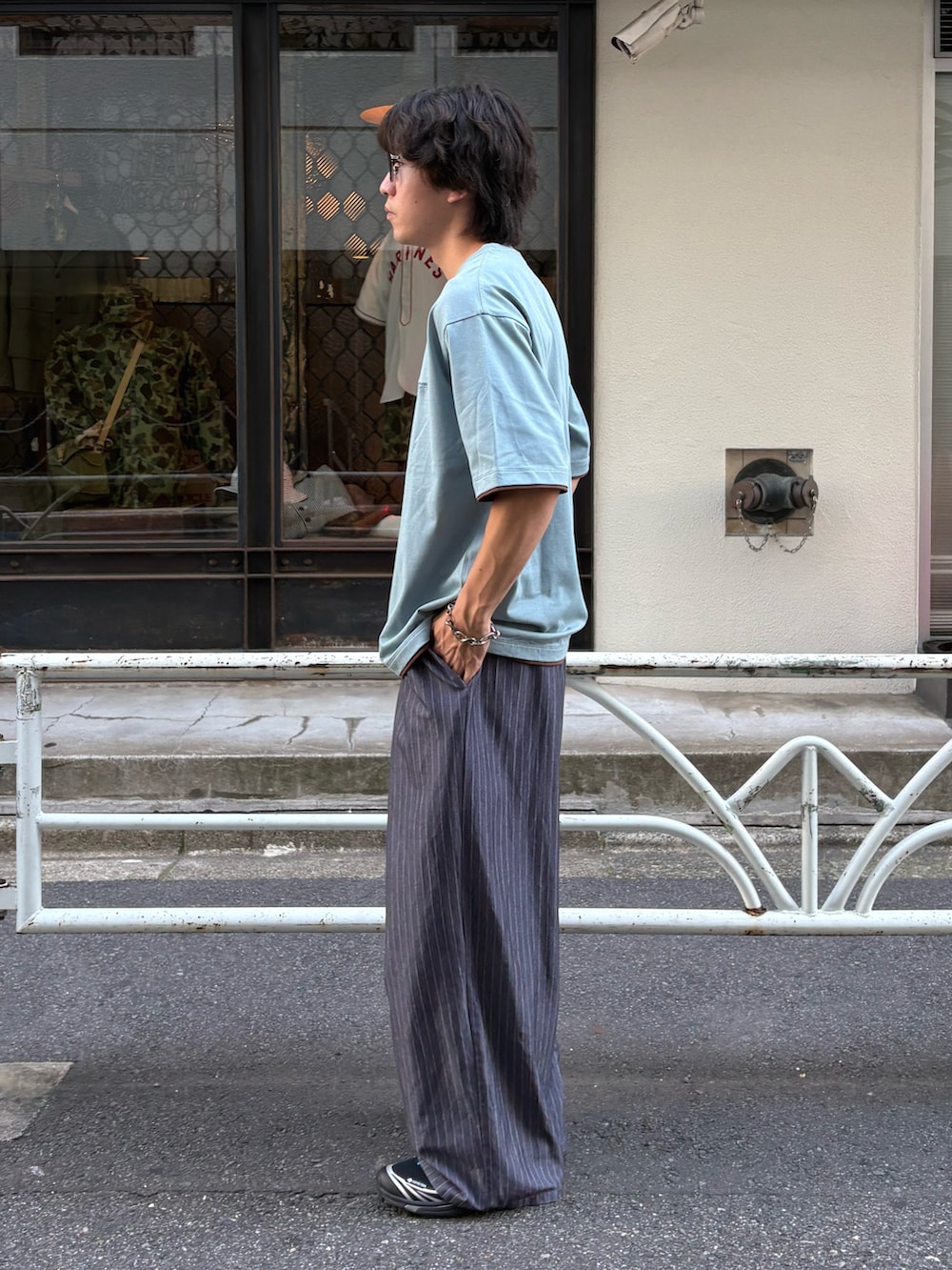 ブルー系のTシャツ/カットソー、グレー系のスラックスを着用したメンズの夏コーディネートの2枚目の写真