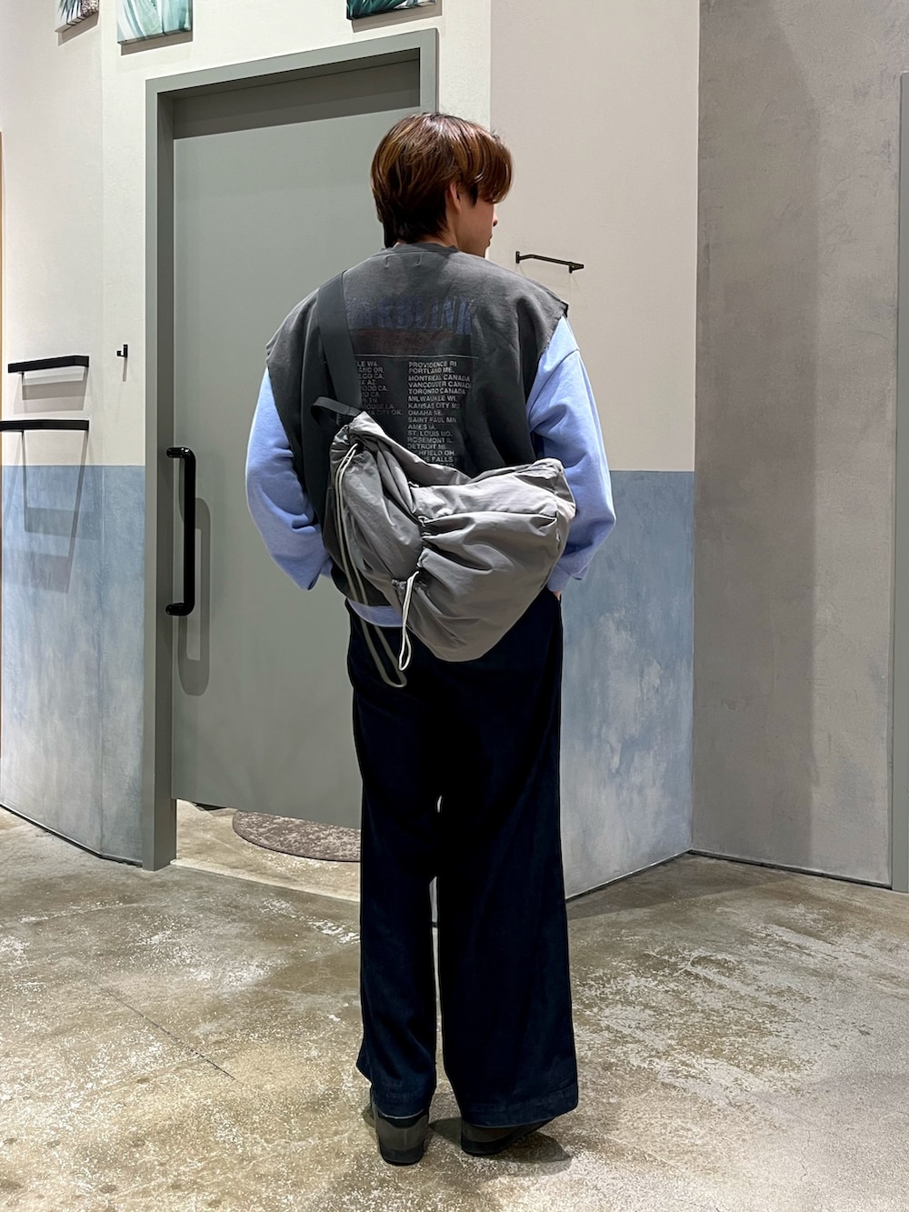 グレー系のスニーカー、ブルー系のデニムパンツ、ブルー系のスウェットを着用したメンズの冬コーディネートの3枚目の写真