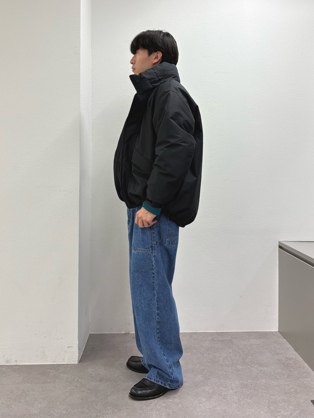 ブラック系のダウンジャケット/コート、ブルー系のデニムパンツを着用したメンズの冬コーディネートの2枚目の写真