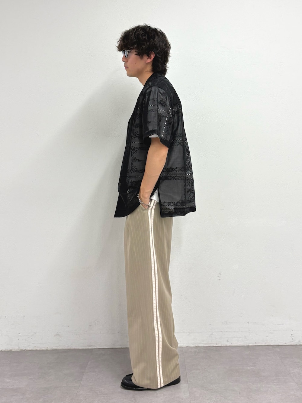 ブラック系のシャツ/ブラウス、ホワイト系のTシャツ/カットソー、ベージュ系のスラックスを着用したメンズの夏コーディネートの2枚目の写真