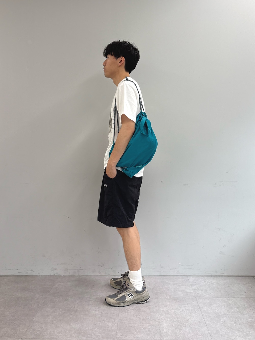 ホワイト系のTシャツ/カットソー、ブルー系のバックパック/リュック、ブラック系のその他パンツを着用したメンズの春コーディネートの2枚目の写真