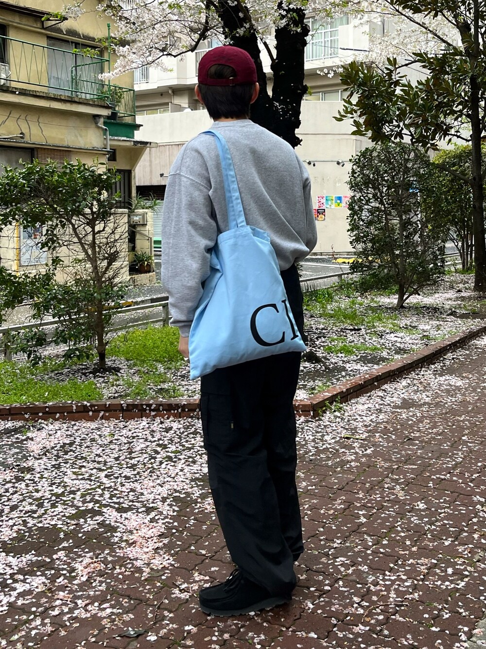 ブラック系のスニーカー、ブラック系のカーゴパンツ、グレー系のスウェットを着用したメンズの春コーディネートの2枚目の写真