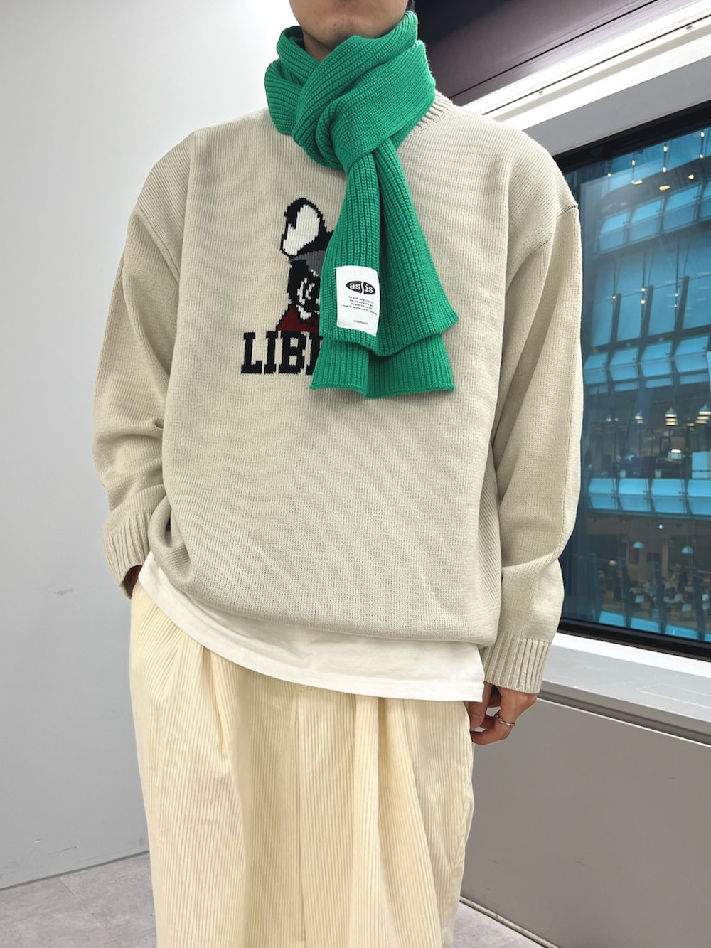 ホワイト系のニット/セーター、ホワイト系のパンツ、ブラック系のスニーカーを着用したメンズの秋コーディネートの3枚目の写真