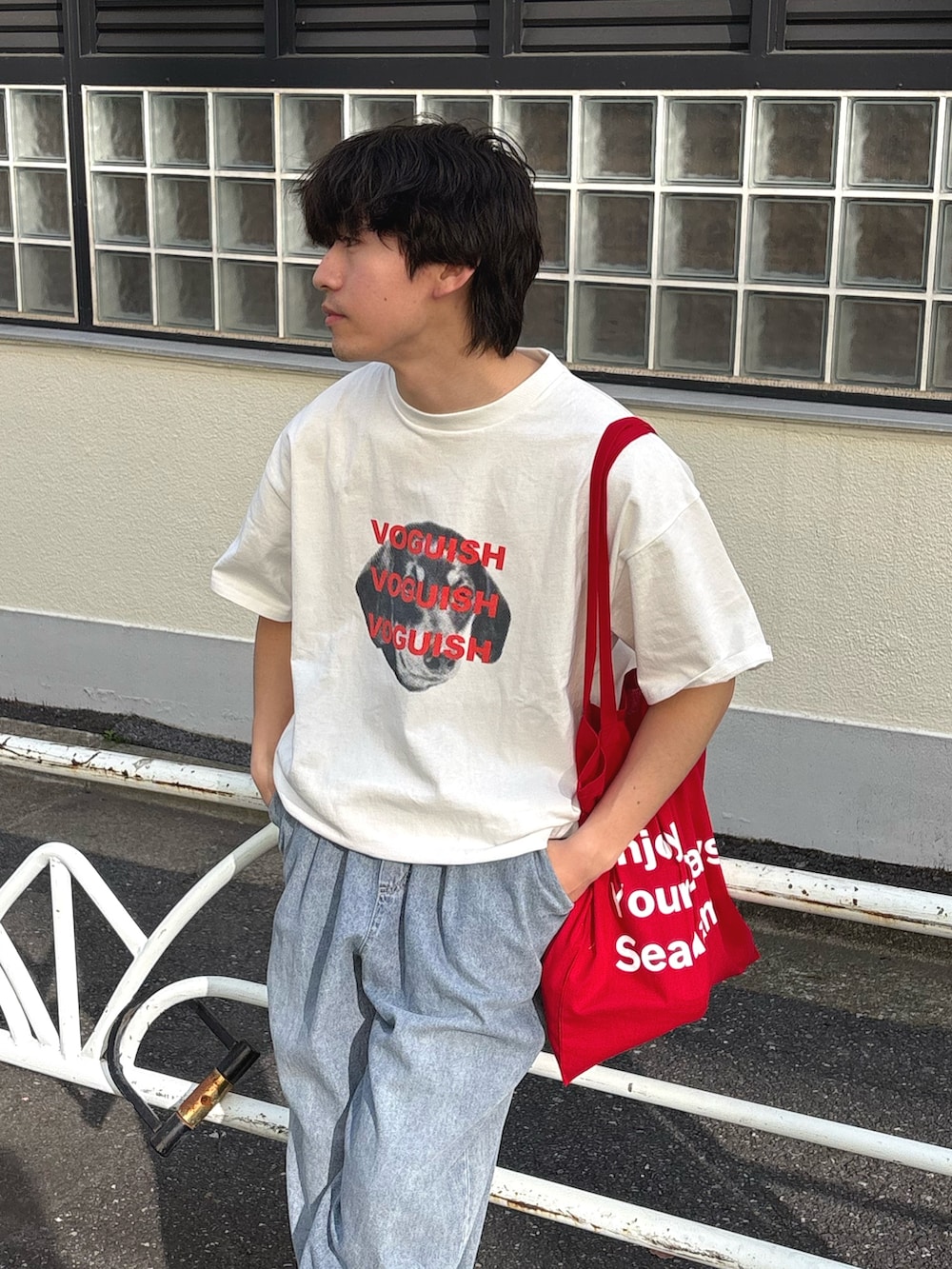 ホワイト系のTシャツ/カットソー、レッド系のトートバッグ、ブルー系のデニムパンツを着用したメンズの春コーディネートの2枚目の写真