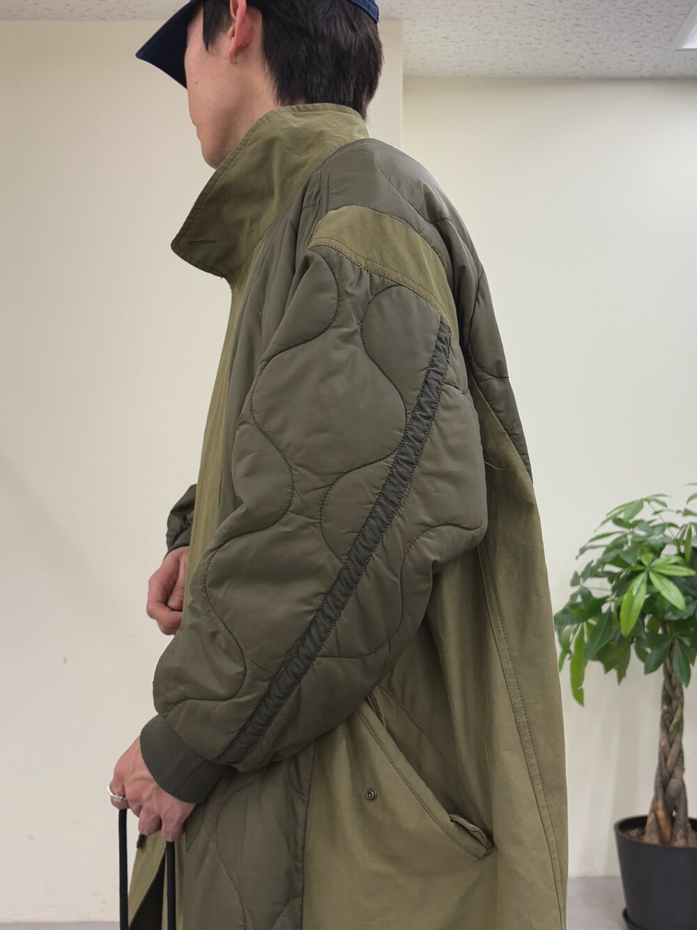 ブルー系のスウェット、グリーン系のモッズコート、ブラック系のスラックスを着用したメンズの春コーディネートの4枚目の写真