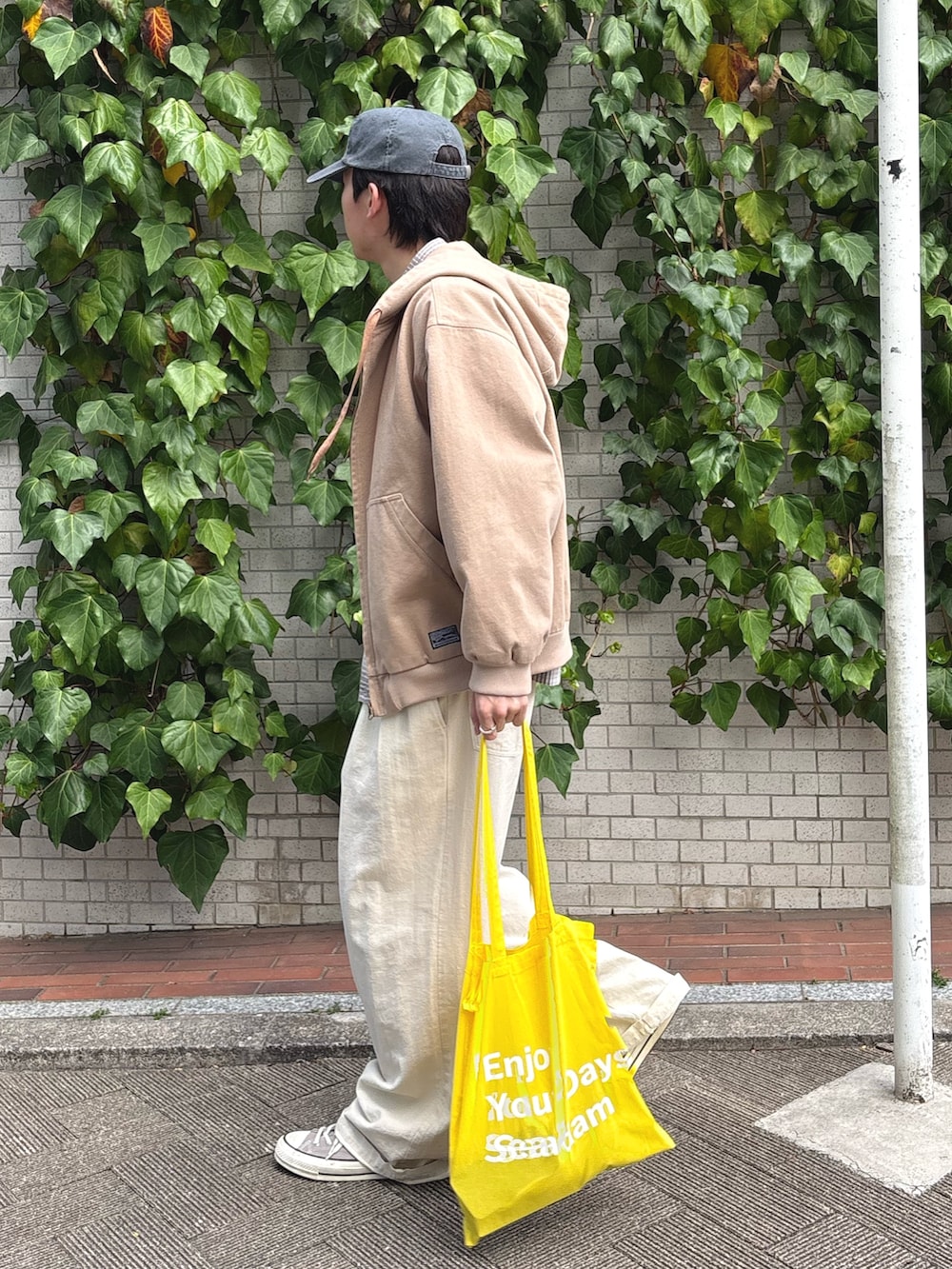 ベージュ系のデニムジャケット、グレー系のシャツ/ブラウス、ホワイト系のスラックスを着用したメンズの春コーディネートの2枚目の写真