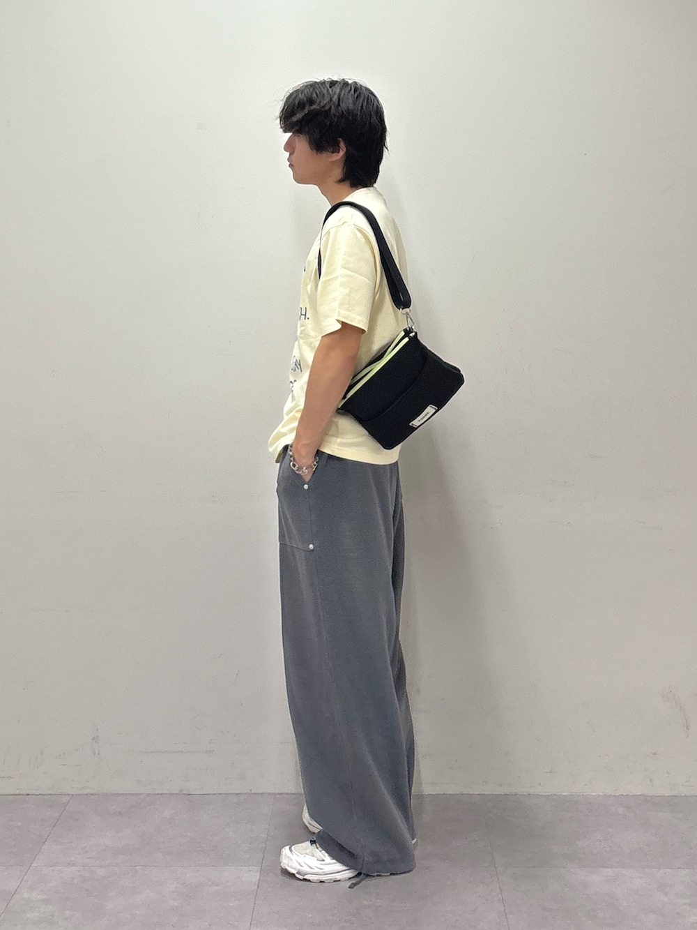 ベージュ系のTシャツ/カットソー、ブラック系のショルダーバッグ、グレー系のスウェットパンツを着用したメンズの夏コーディネートの2枚目の写真
