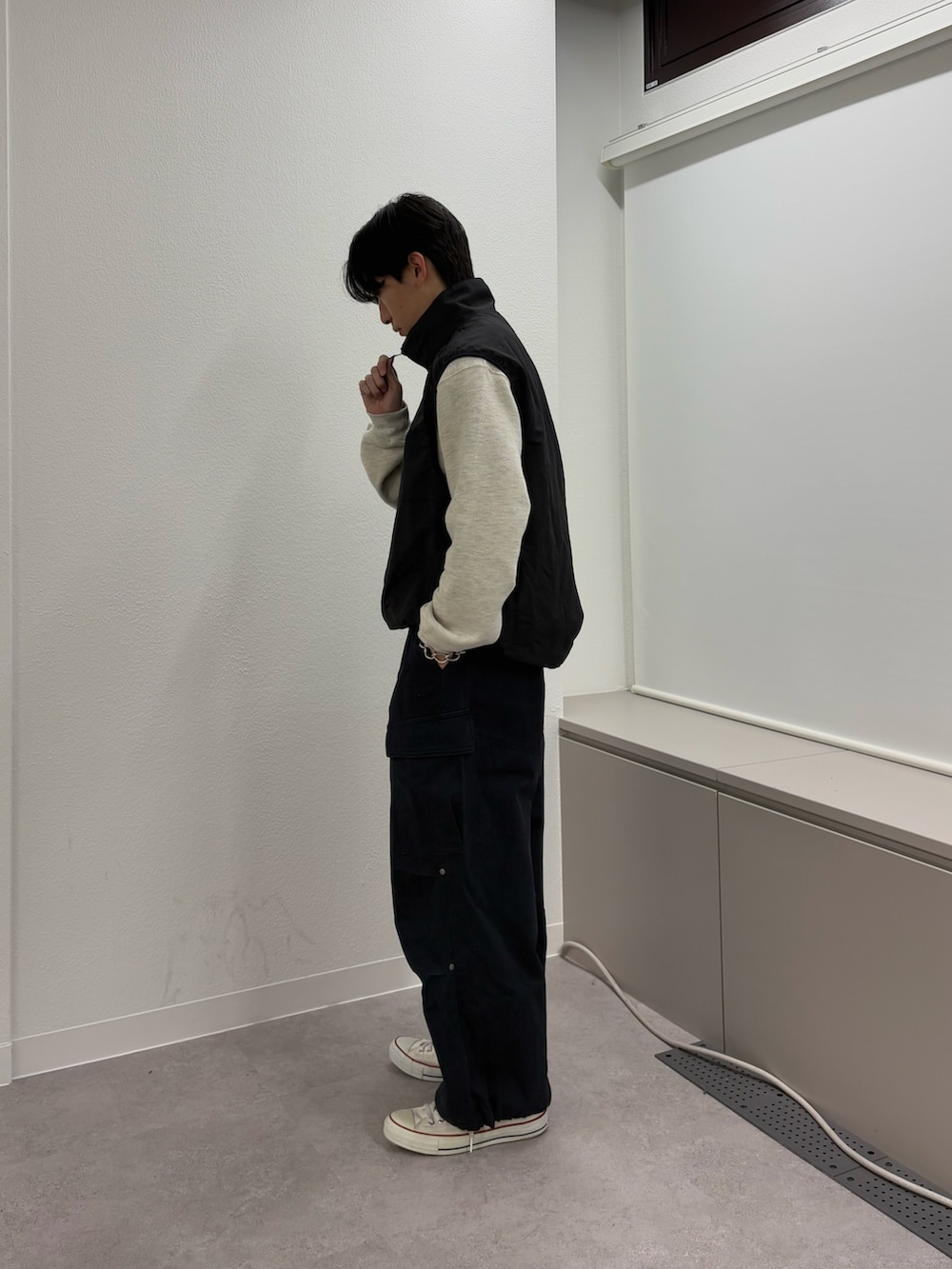 グレー系のスウェット、ブラック系のベスト、ブルー系のその他パンツを着用したメンズの冬コーディネートの2枚目の写真