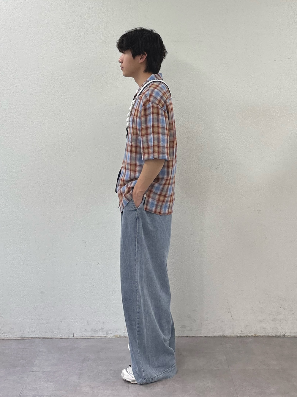 レッド系のシャツ/ブラウス、ブラック系のショルダーバッグ、ブルー系のデニムパンツを着用したメンズの春コーディネートの2枚目の写真