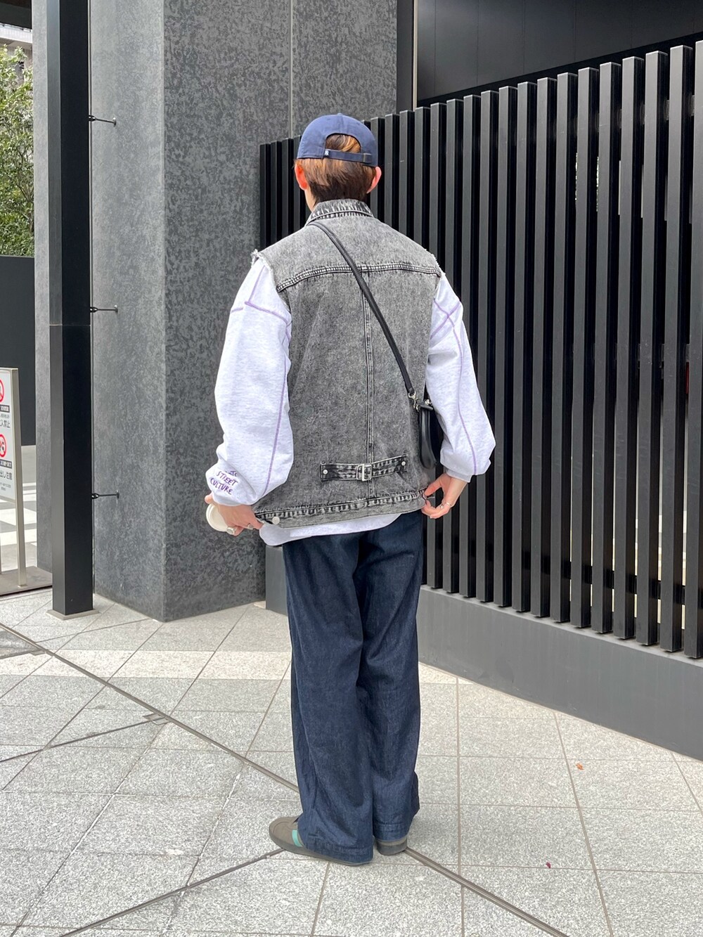 グレー系のスウェット、ブラック系のベスト、ブルー系のデニムパンツを着用したメンズの冬コーディネートの2枚目の写真