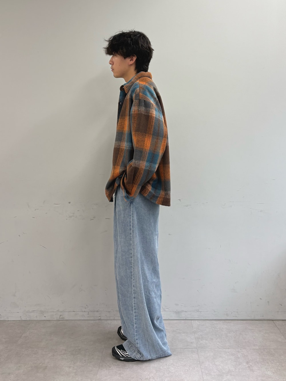 オレンジ系のシャツ/ブラウス、ホワイト系のTシャツ/カットソー、ブルー系のデニムパンツを着用したメンズの秋コーディネートの2枚目の写真