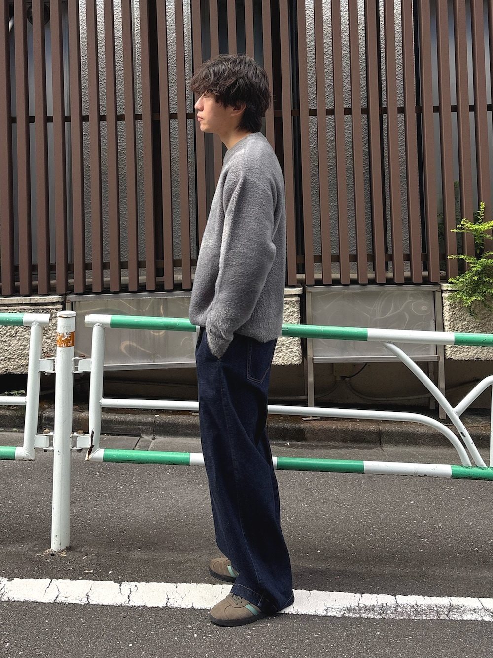 グレー系のニット/セーター、ブルー系のデニムパンツを着用したメンズの秋コーディネートの2枚目の写真