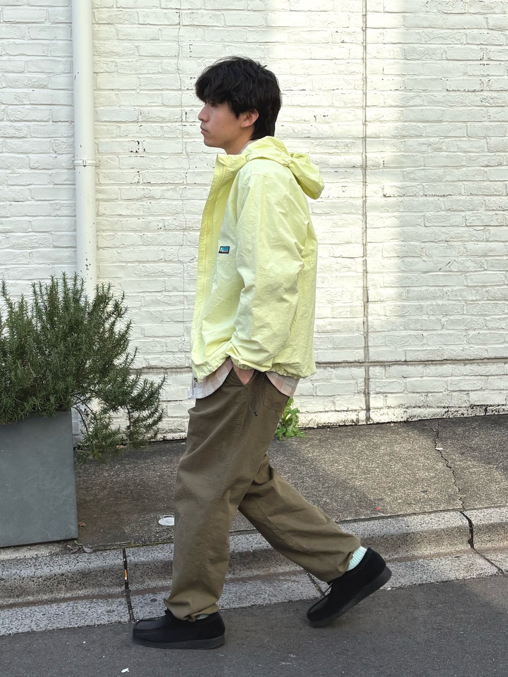 イエロー系のマウンテンパーカー、ピンク系のシャツ/ブラウス、グリーン系のカーゴパンツを着用したメンズの春コーディネートの2枚目の写真