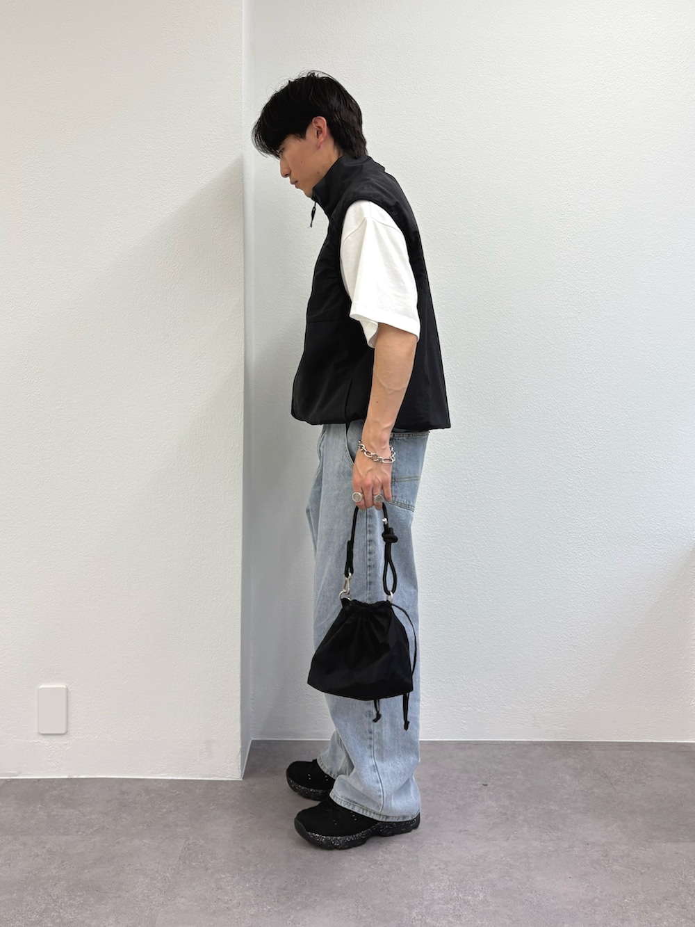 ブラック系のベスト、ホワイト系のTシャツ/カットソー、ブルー系のデニムパンツを着用したメンズの夏コーディネートの2枚目の写真