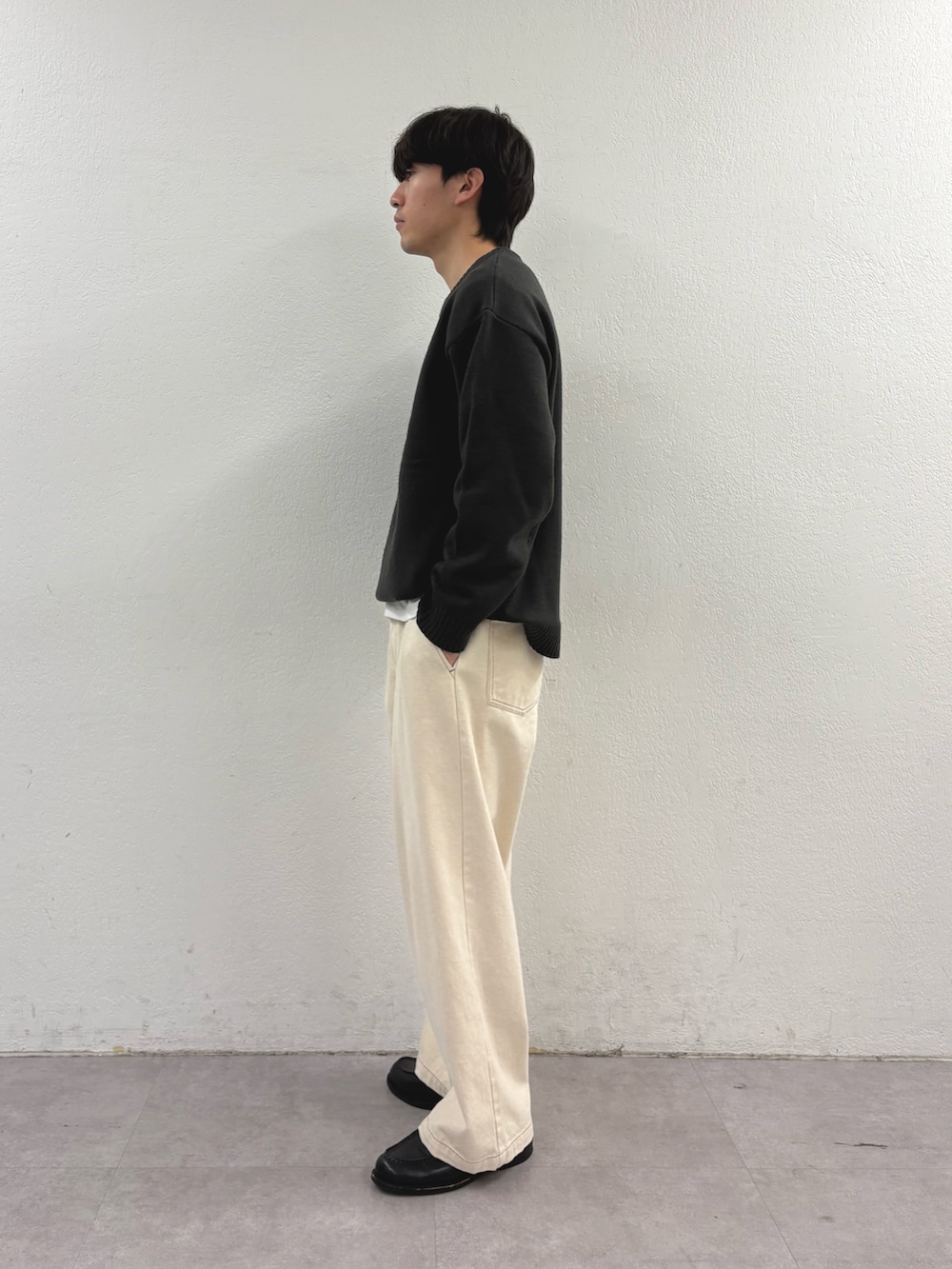 グレー系のニット/セーター、ホワイト系のデニムパンツを着用したメンズの冬コーディネートの2枚目の写真