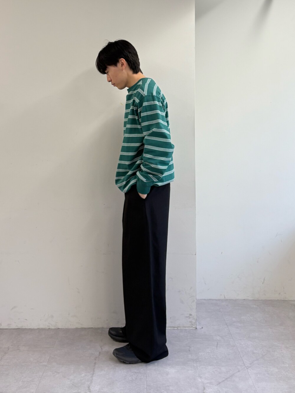 グリーン系のTシャツ/カットソー、ブラック系のスラックスを着用したメンズの春コーディネートの2枚目の写真