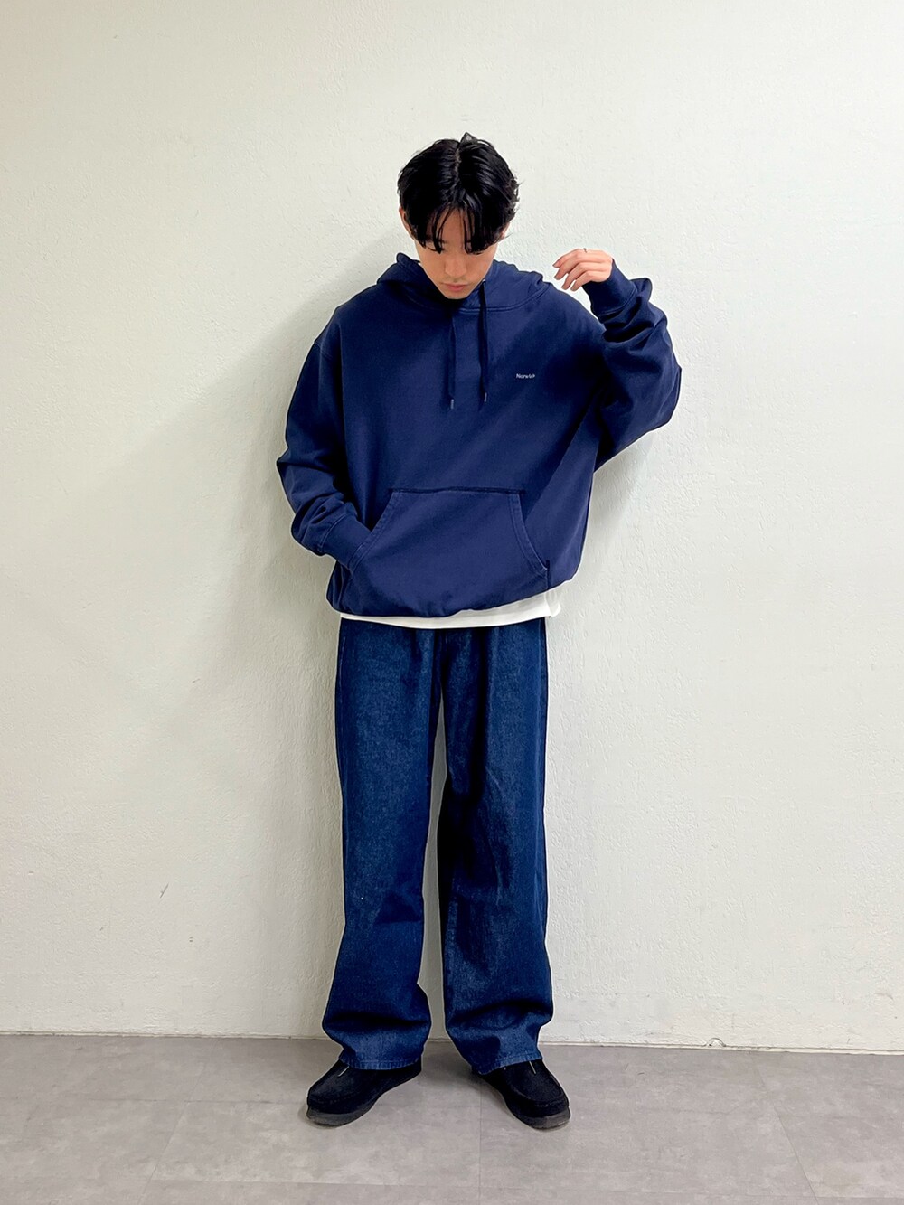 ブルー系のパーカー、ブルー系のデニムパンツ、ブラック系のスニーカーを着用したメンズの秋コーディネートの2枚目の写真