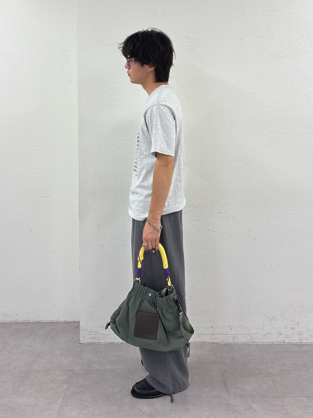 グレー系のTシャツ/カットソー、グレー系のスウェットパンツ、グリーン系のトートバッグを着用したメンズの夏コーディネートの2枚目の写真