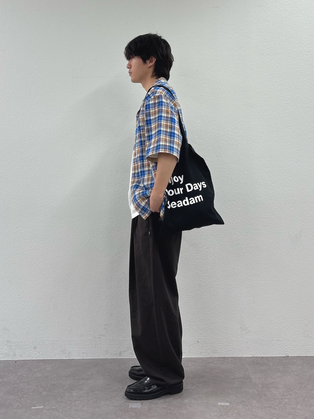 ブルー系のシャツ/ブラウス、ホワイト系のTシャツ/カットソー、ブラック系のトートバッグを着用したメンズの春コーディネートの2枚目の写真