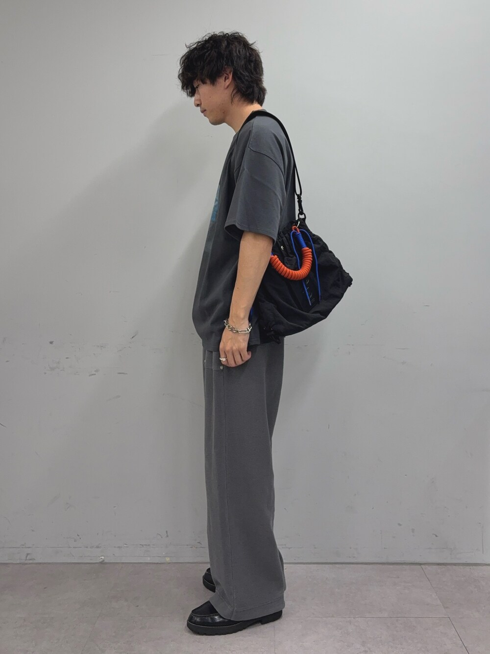 グレー系のTシャツ/カットソー、ブラック系のトートバッグ、グレー系のスウェットパンツを着用したメンズの夏コーディネートの2枚目の写真